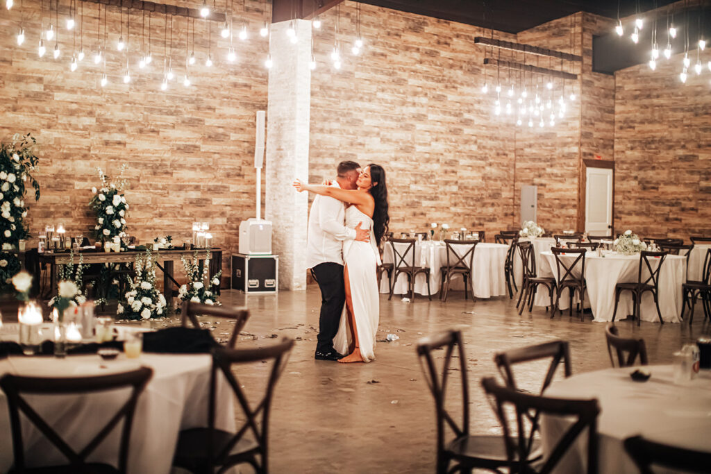 The couple sharing a tender moment during their last dance, surrounded by the warm glow of Gentry Pines.