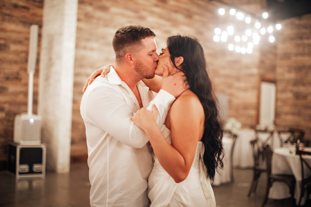 The couple sharing a tender moment during their last dance, surrounded by the warm glow of Gentry Pines.