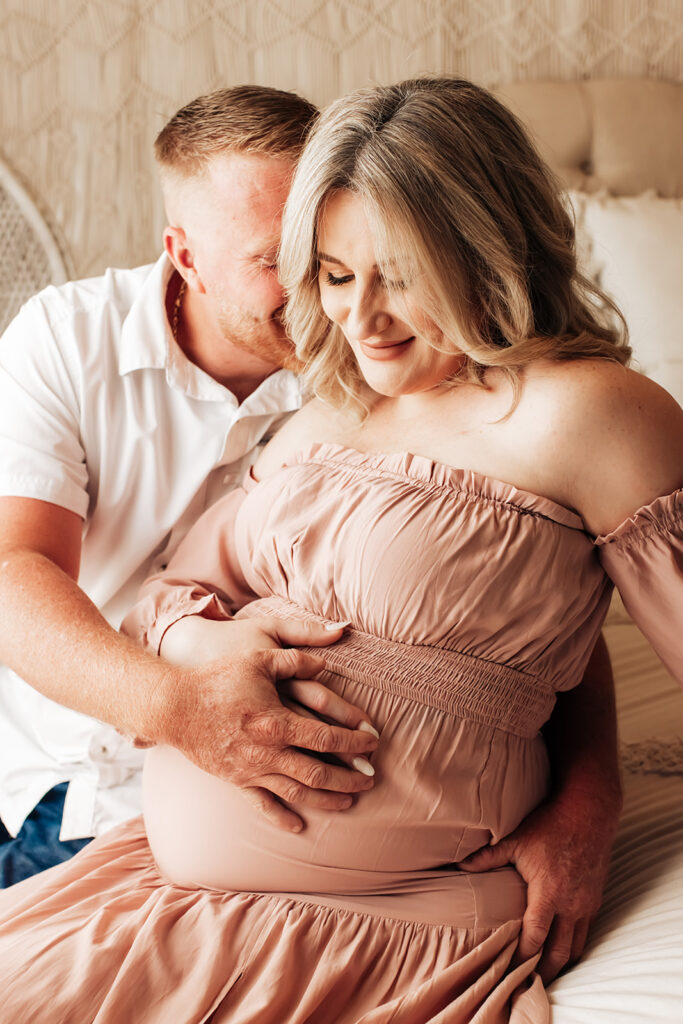 Expectant mother smiling during a studio maternity photoshoot at Wings of Glory Photography