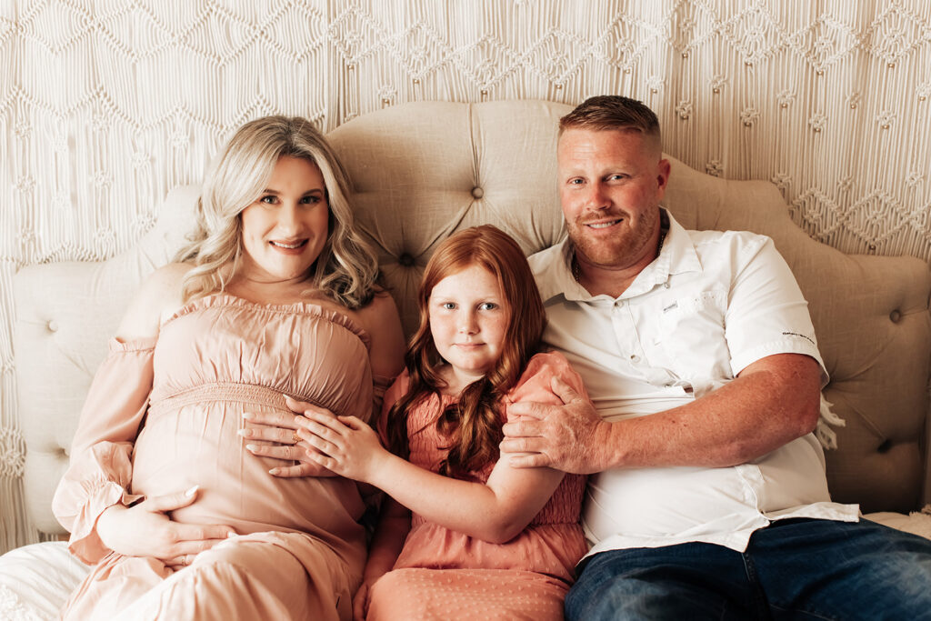 Expectant mother smiling during a studio maternity photoshoot at Wings of Glory Photography