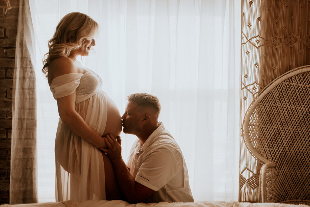 Expectant mother smiling during a studio maternity photoshoot at Wings of Glory Photography