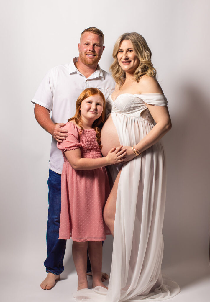 Expectant mother smiling during a studio maternity photoshoot at Wings of Glory Photography