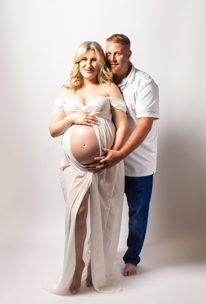 Expectant mother smiling during a studio maternity photoshoot at Wings of Glory Photography