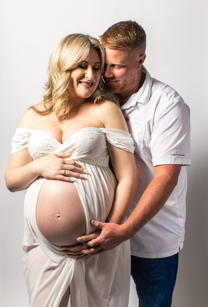 Expectant mother smiling during a studio maternity photoshoot at Wings of Glory Photography