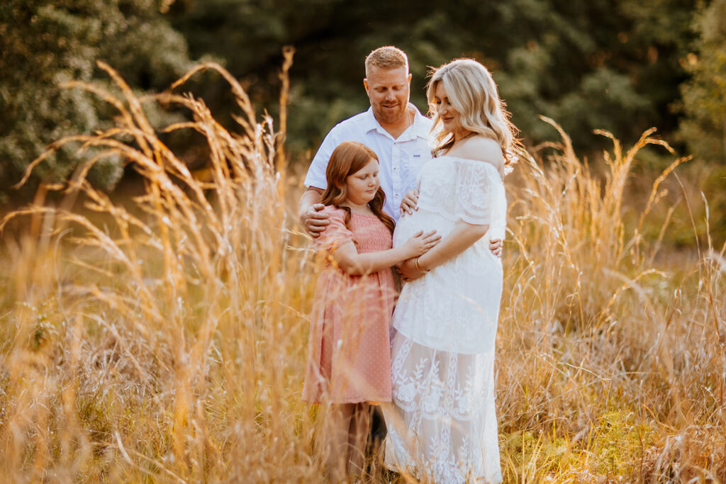 Pregnant couple walking hand in hand through a picturesque outdoor location during a maternity photoshoot with Wings of Glory Photography