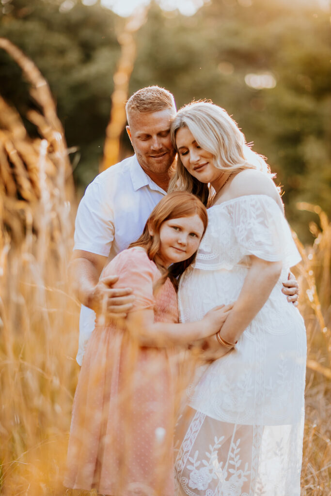 Pregnant couple walking hand in hand through a picturesque outdoor location during a maternity photoshoot with Wings of Glory Photography