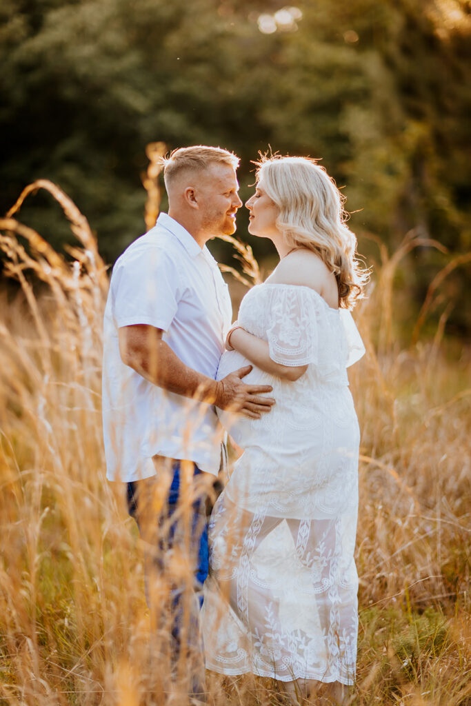 Pregnant couple walking hand in hand through a picturesque outdoor location during a maternity photoshoot with Wings of Glory Photography