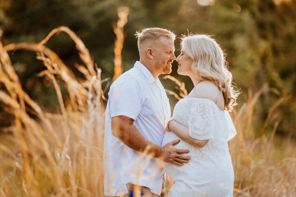 Pregnant couple walking hand in hand through a picturesque outdoor location during a maternity photoshoot with Wings of Glory Photography