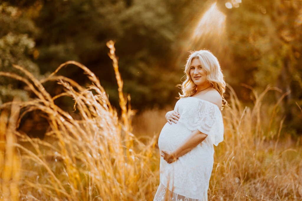 Pregnant couple walking hand in hand through a picturesque outdoor location during a maternity photoshoot with Wings of Glory Photography