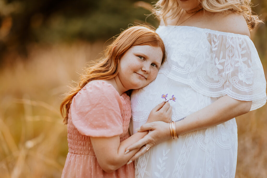 Pregnant couple walking hand in hand through a picturesque outdoor location during a maternity photoshoot with Wings of Glory Photography