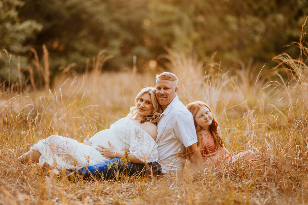 Pregnant couple walking hand in hand through a picturesque outdoor location during a maternity photoshoot with Wings of Glory Photography