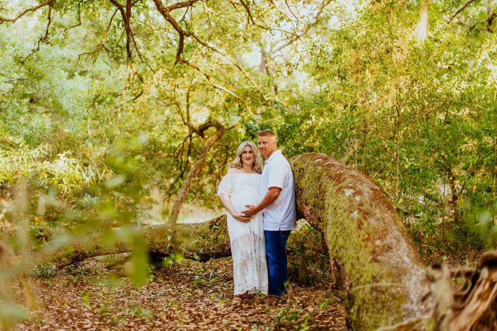 Pregnant couple walking hand in hand through a picturesque outdoor location during a maternity photoshoot with Wings of Glory Photography