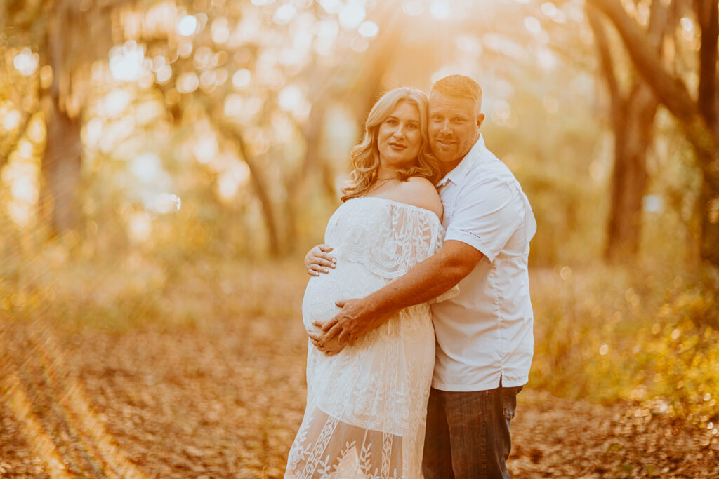 Pregnant couple walking hand in hand through a picturesque outdoor location during a maternity photoshoot with Wings of Glory Photography