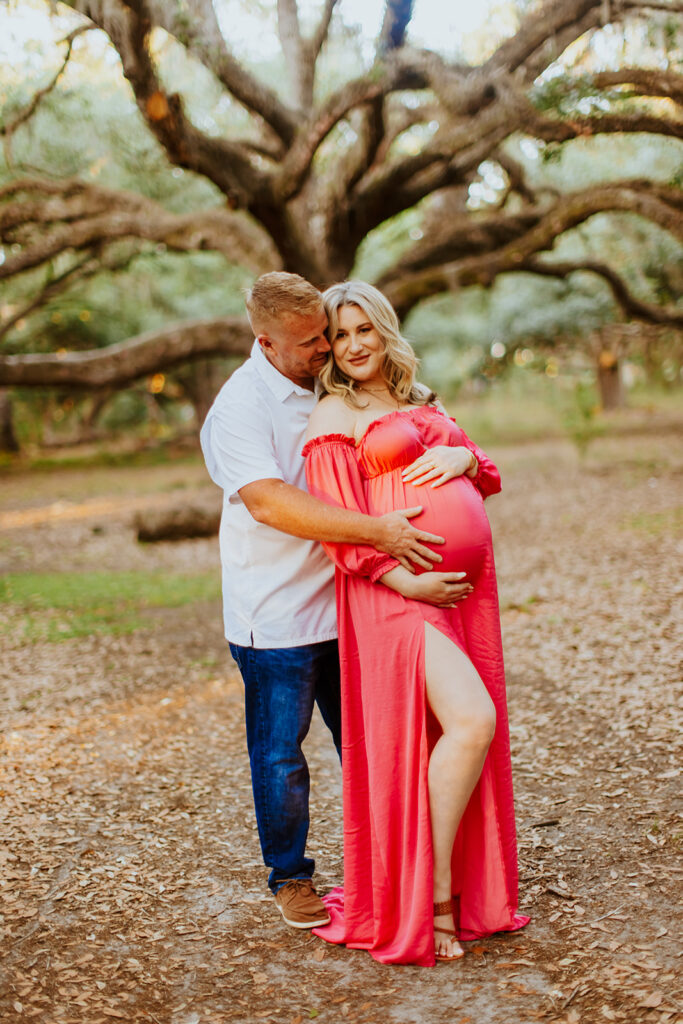 Pregnant couple walking hand in hand through a picturesque outdoor location during a maternity photoshoot with Wings of Glory Photography